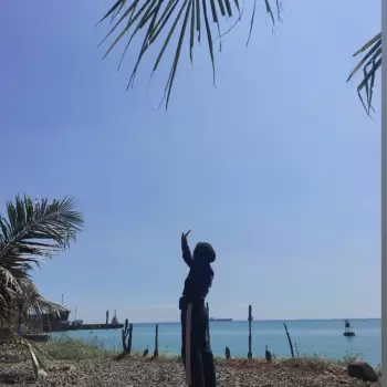 pantai, laut, langit biru, perempuan, berhijab, pohon kelapa, dedaunan, dermaga, kapal, perahu, awan, cuaca cerah, liburan, perjalanan, pemandangan, alam, luar ruangan, musim panas, tropis, santai, bahagia, muda, olahraga, rekreasi, aksesori, tas, sepatu, jalan-jalan, pemandangan laut, foto.