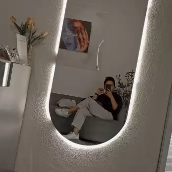 cermin, pantulan, orang, pria, duduk, kursi, sofa, kafe, interior, modern, minimalis, pencahayaan, lampu, estetika, santai, nyaman, memegang, cangkir, kopi, telepon, tangan, kaki, sepatu, kacamata, rambut pendek, baju, celana, poster, dinding, bunga