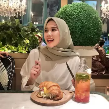 wanita berhijab, makanan, croissant, minuman, restoran, kafe, makan siang, sarapan, wanita cantik, wanita muslim, senyum, gaya hidup, kuliner, dessert, salad, hidangan, segar, alami, dekorasi, interior, mewah, elegan, suasana, nyaman, santai, hari cerah, wanita bahagia, menikmati makanan, piring kayu, botol kaca.