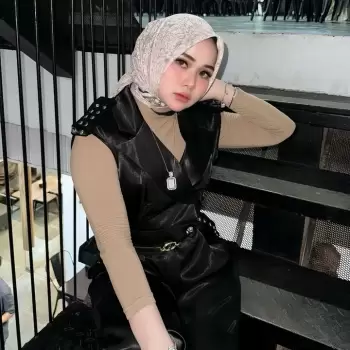 wanita, berhijab, pakaian, fashion, gaya, modern, kasual, pakaian luar, rompi, kulit, atasan, lengan panjang, warna netral, celana, sepatu, aksesori, kalung, gelang, tas, sepatu, tangga, interior, restoran, kafe, duduk, santai, pose, melihat kamera, cantik, muda.