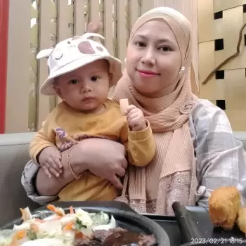 ibu dan anak, bayi, wanita, hijab, topi bayi, anak lucu, makanan, makan bersama, santai, keluarga, kebahagiaan, senyum, makan siang, makan malam, restoran, waktu berkualitas, nyaman, kasih sayang, hubungan ibu anak, momen, bahagia, potret, indoor, terang, siang hari, kasual, pakaian nyaman, wajah, pemandangan, kebersamaan