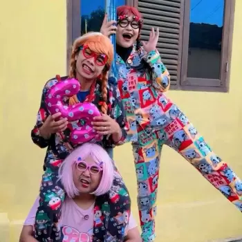 tiga orang, badut, kostum lucu, piyama, rambut palsu, kacamata, balon angka, perayaan, kegembiraan, tawa, ekspresi wajah, ceria, menggemaskan, anak-anak, keluarga, persahabatan, kebersamaan, bermain, pesta, hari ulang tahun, gaya kocak, unik, berwarna-warni, budaya, indonesia, lokal, ekspresi, seni, konten kreatif