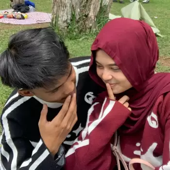 pasangan muda, muda mudi, berpacaran, romantis, mesra, kekasih, cinta, kasih sayang, kencan, kebersamaan, luar ruangan, alam, taman, piknik, duduk, santai, bahagia, senyum, tertawa, berbagi cerita, bisikan, rahasia, kedekatan, tatapan mata, saling memandang, pemuda, gadis, wanita berhijab, pria, ekspresi wajah.